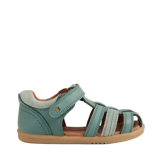 Green sandal with brown sole on a light gray background
