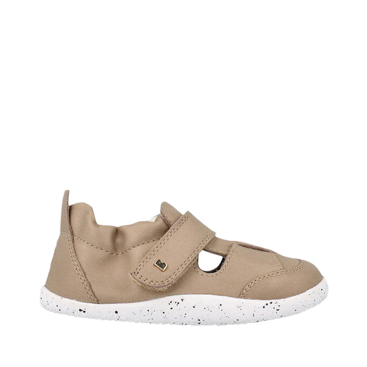 Beige children's shoe with a white sole on a light gray background