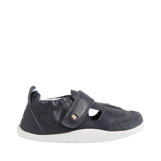 Navy blue children's shoe with a strap on a light gray background