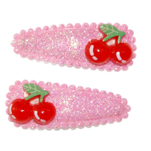 Two pink hair clips with red cherries on a white background