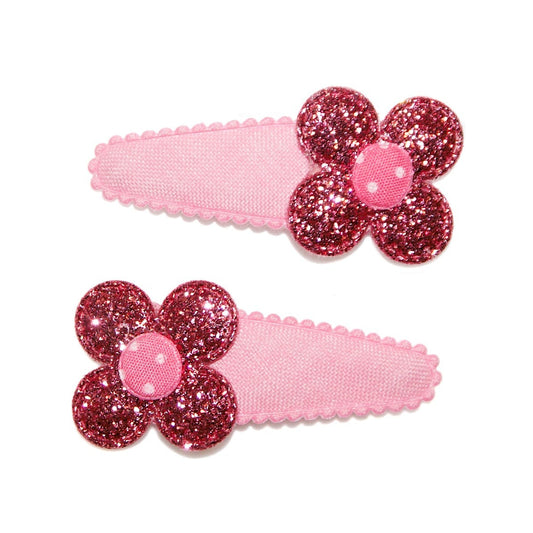 Two pink hair clips with glittery flower designs on a white background
