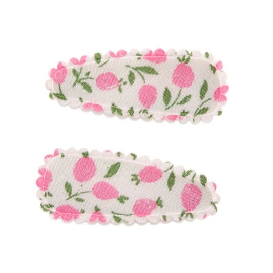 Two floral hair clips on a white background
