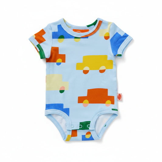 A baby short-sleeve bodysuit in light blue with a colorful pattern of cartoon cars and geometric shapes in orange, yellow, green, and blue, shown on a white background.