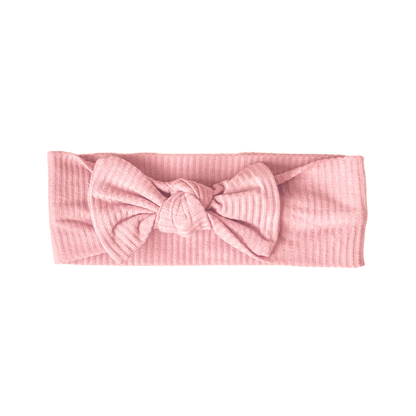 Pink ribbed headband with a bow on a white background