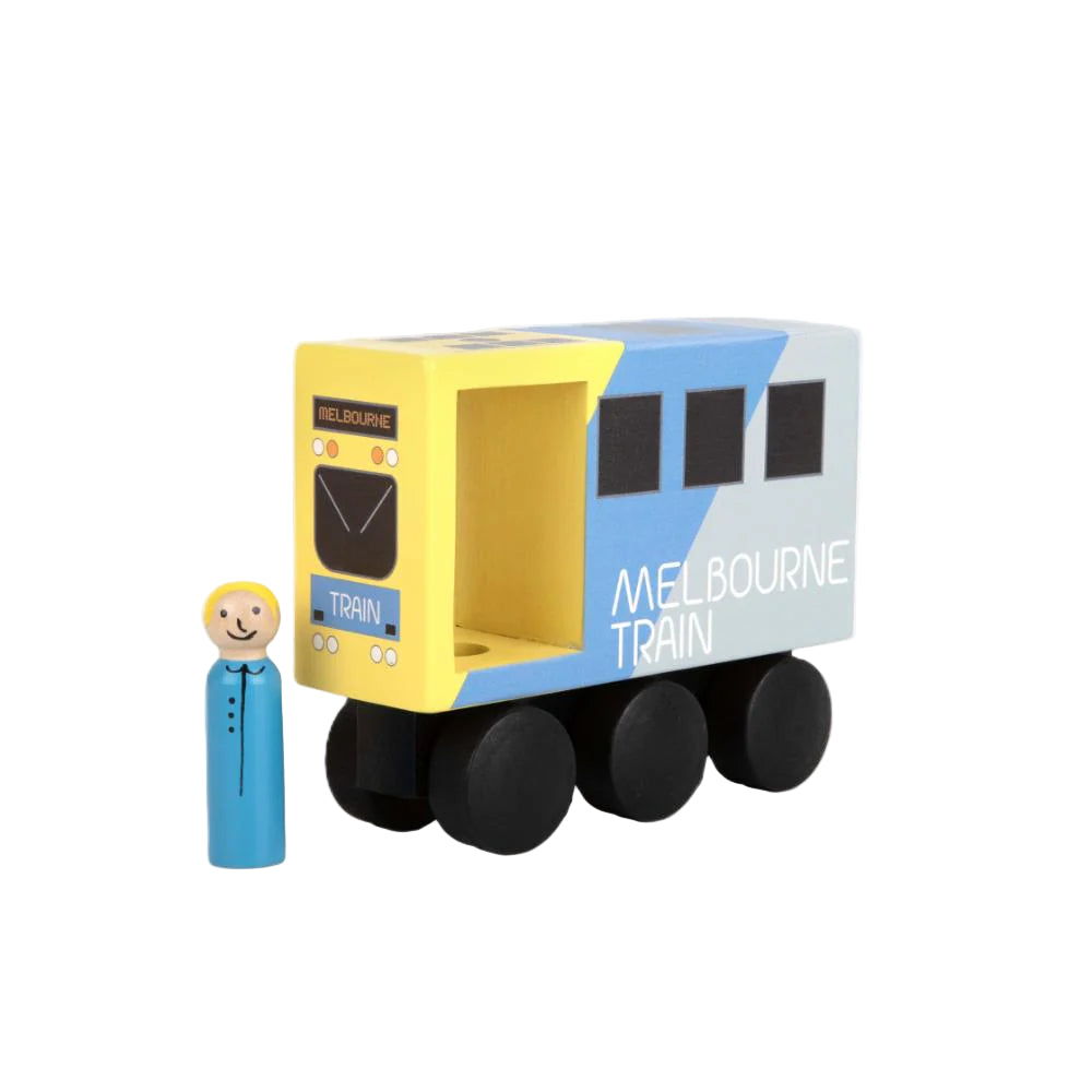 Toy train model of a Melbourne train with a small figure next to it on a white background