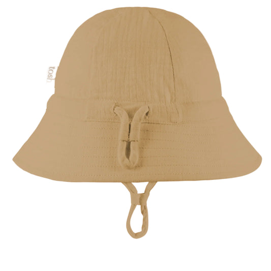 Beige sun hat with UPF 50+ label on a light gray background