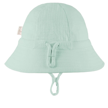 Light green bucket hat with UPF 50+ sun safety label on a white background