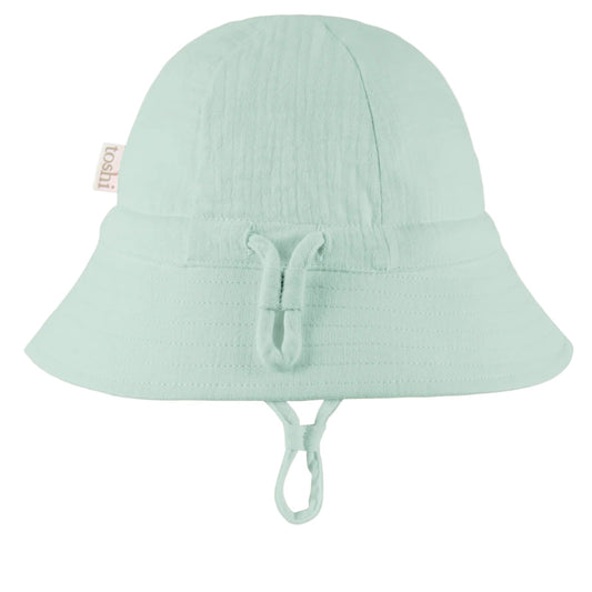 Light green bucket hat with UPF 50+ sun safety label on a white background