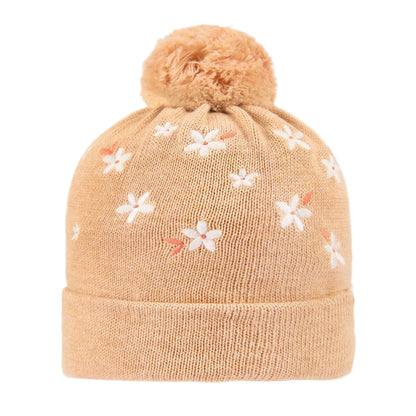 Beige knit beanie with floral patterns and a pom-pom on a white background